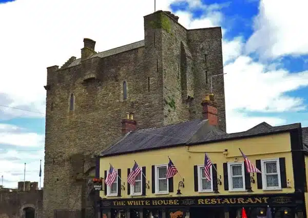 Roscrea Castle, Ireland with the white house pub in front