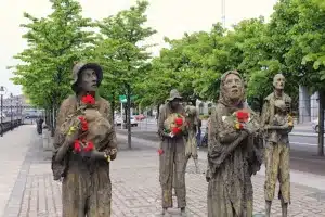 Irish potato famine statues with fresh flowers decorating them