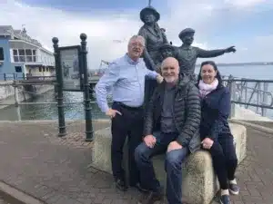 Annie Moore statue in Cobh, County Cork, Ireland with Mike and Carina sitting in front