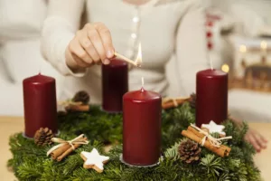 Advent candles being lit on a christmas wreath