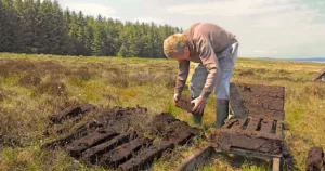 Peat bog in Ireland with man laying out cut turf