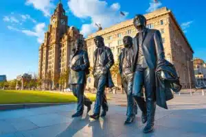 Liverpool, UK - May 17 2018: Bronze statue of the Beatles stands at the Pier Head on the side of River Mersey, sculpted by Andrew Edwards and erected in December 2015