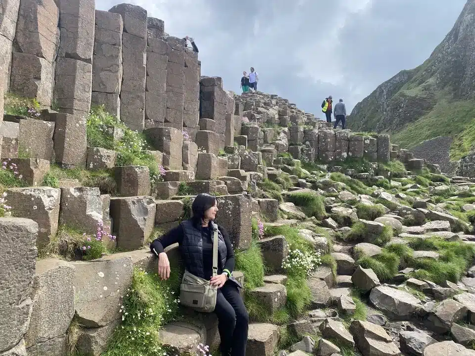 Carina sitting on the Giants Causeway showing some greenery